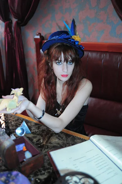Bruxa evoca livros de bruxas na mesa — Fotografia de Stock
