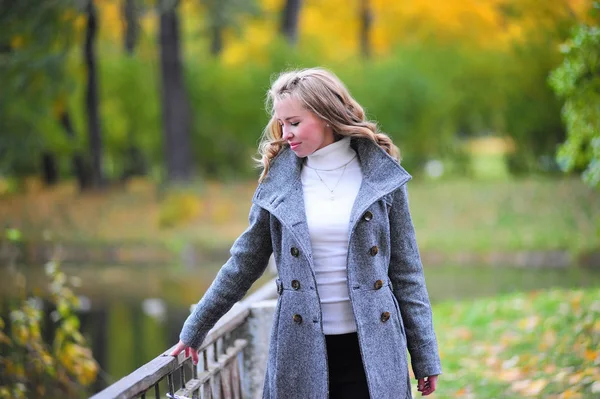 Девушка в сером пальто в парке — стоковое фото