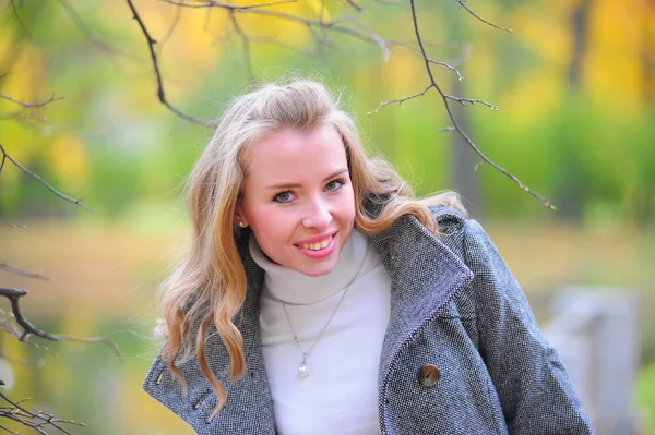 Mädchen im grauen Mantel im Park — Stockfoto