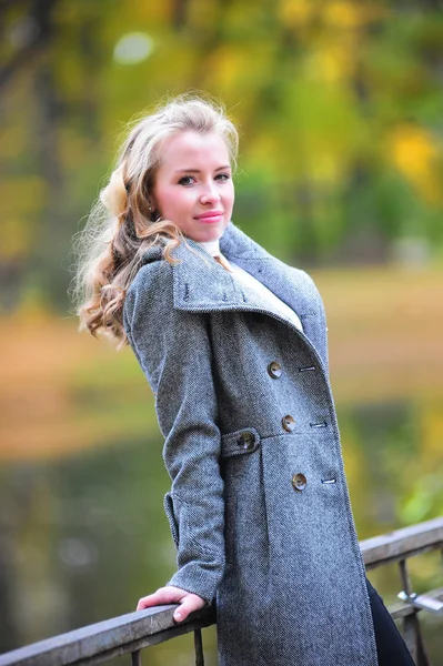 Girl in a gray coat in  park — Stock Photo, Image