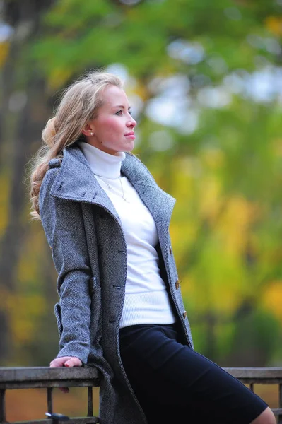 Mädchen im grauen Mantel im Park — Stockfoto