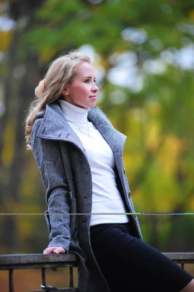 Mädchen im grauen Mantel im Park — Stockfoto