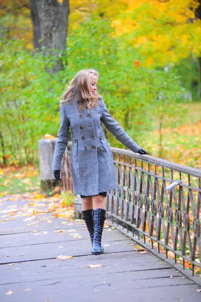 Девушка в сером пальто в парке — стоковое фото