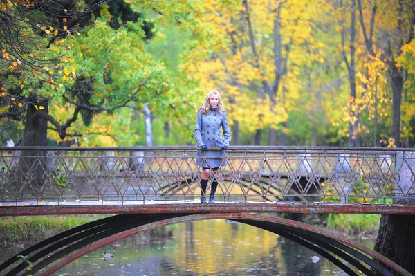 Mädchen im grauen Mantel im Herbstpark — Stockfoto