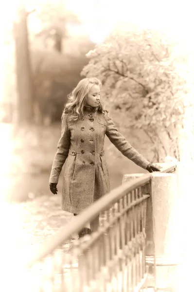 Dziewczyna w szarym płaszczu w jesiennym parku — Zdjęcie stockowe