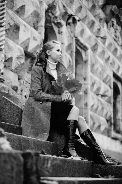 Taş bir merdivenin basamaklarında gri montlu kız. — Stok fotoğraf