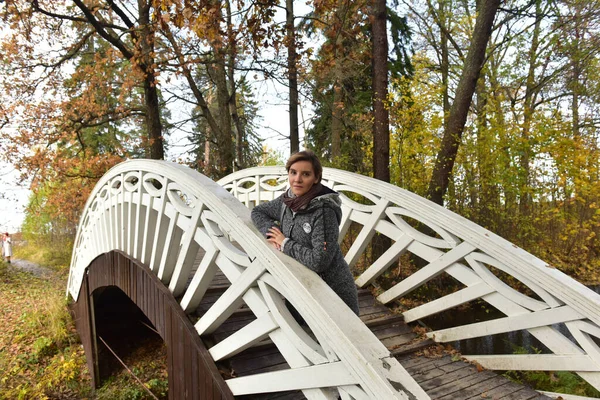 秋天的一座木桥上 一位头发灰白的短发女子 — 图库照片