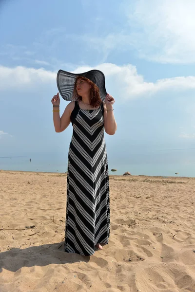 Πορτραίτο Γυναίκας Φαρδύ Καπέλο Και Ριγέ Φόρεμα Φόντο Θάλασσας — Φωτογραφία Αρχείου