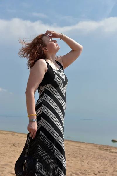 Mulher Vestido Listrado Fundo Mar Com Chapéu Suas Mãos — Fotografia de Stock