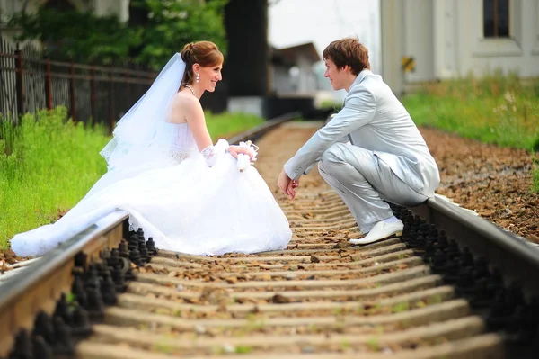 2人の新婚夫婦が線路の上に座り — ストック写真