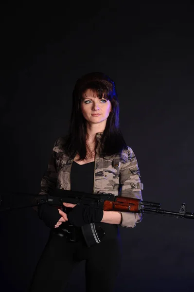 Brünettes Mädchen Mit Waffen Auf Dunklem Hintergrund Studio — Stockfoto