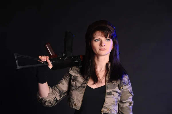 Brünettes Mädchen Mit Waffen Auf Dunklem Hintergrund Studio — Stockfoto
