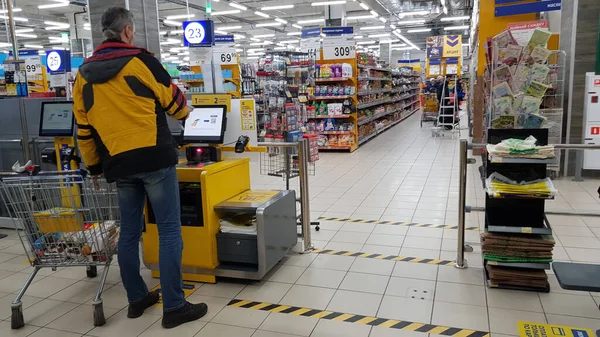 俄罗斯 圣彼得堡2020年3月24日结帐区的顾客和在验尸官流行病流行期间标示到超级市场楼层距离的标志 — 图库照片