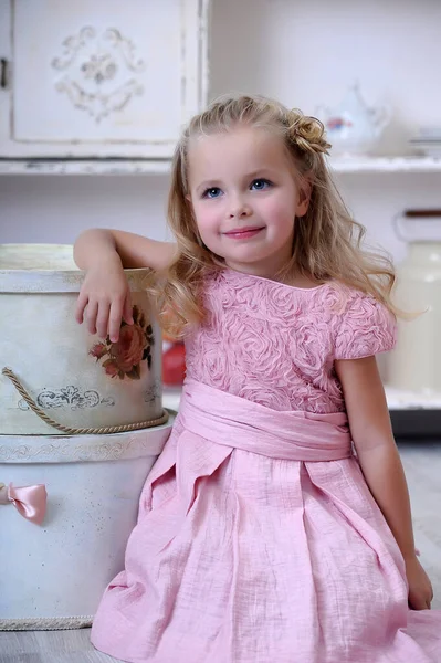 かわいいですブロンド女の子でピンクドレスとともにカールとともにヴィンテージ大きな帽子ボックス — ストック写真