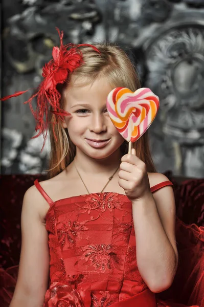 Blond Meisje Een Rode Jurk Met Snoep Haar Handen — Stockfoto