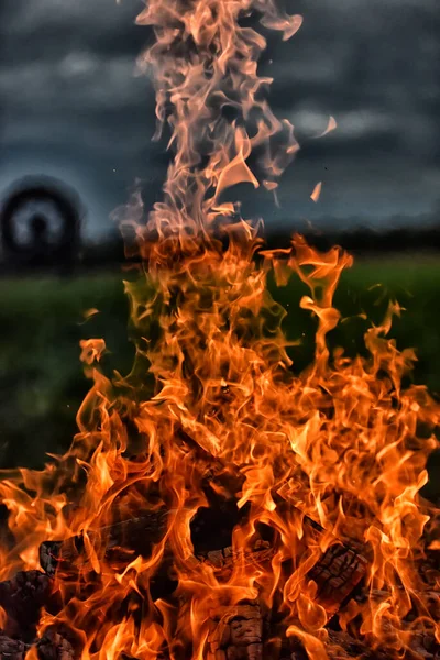 Ognisko Płomienie Przeciwko Ciemnemu Niebu Polu — Zdjęcie stockowe