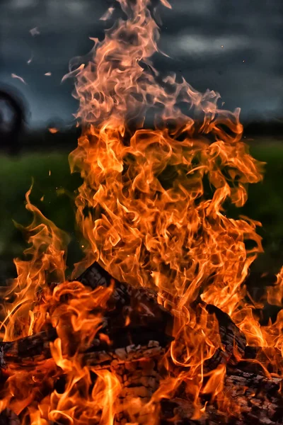 火と炎が野原の暗い空に対して — ストック写真