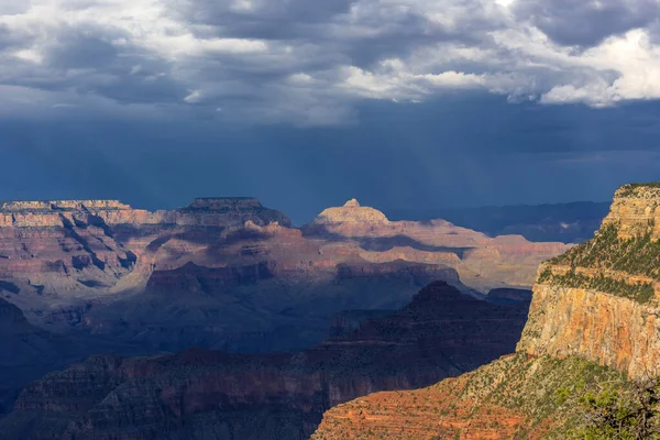 Dark storm clouds and shafts of light over the Grand Canyon