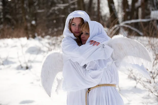 Zwei Mädchen Mit Weißen Kapuzenpullis Mit Engelsflügeln Auf Winterlichem Hintergrund — Stockfoto