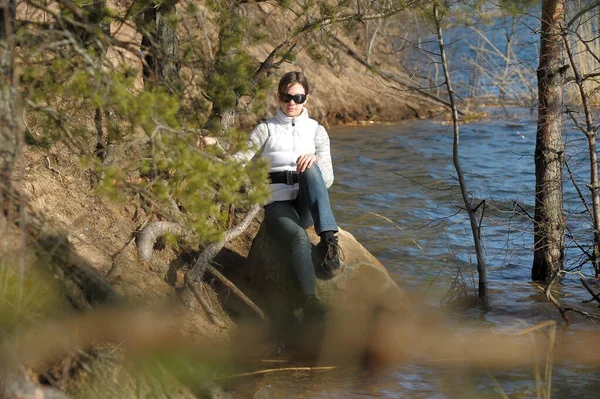 少女坐在水边的岩石上 — 图库照片