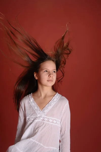 Ragazza Bruna Bambino Studio Uno Sfondo Rosso Con Capelli Volanti — Foto Stock