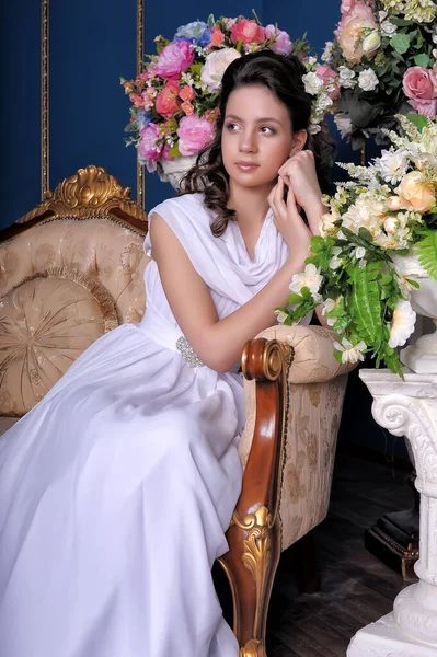Młoda Brunetka Białej Sukience Siedzi Krześle Vintage Portret Wśród Kwiatów — Zdjęcie stockowe