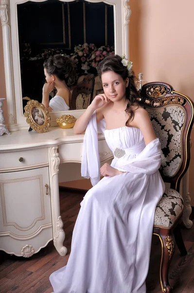 Beyaz Elbiseli Zarif Kız Aynanın Yanındaki Sandalyede Oturuyor — Stok fotoğraf