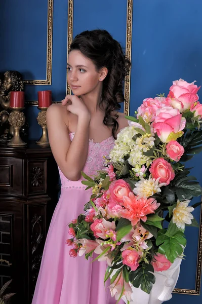 Odadaki Çiçeklerin Arasında Pembe Zarif Elbiseli Esmer Kız — Stok fotoğraf