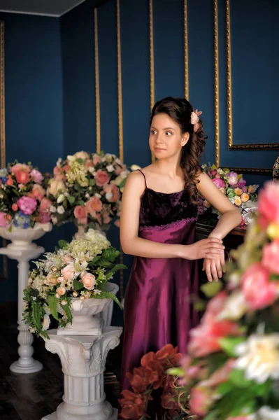 Jong Brunette Meisje Een Bourgogne Elegante Jurk Tussen Bloemen Kamer — Stockfoto
