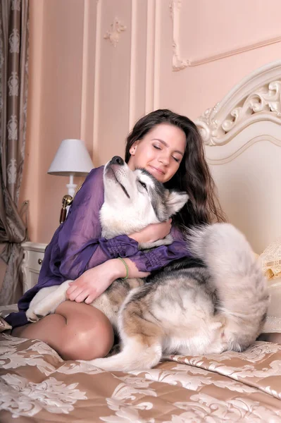 Jovem Menina Vestido Lilás Com Seu Malamute Cama — Fotografia de Stock