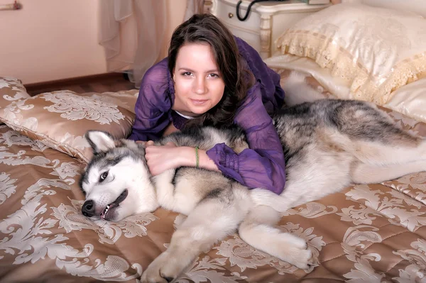 Ung Flicka Lila Klänning Med Sin Malamute Sängen — Stockfoto