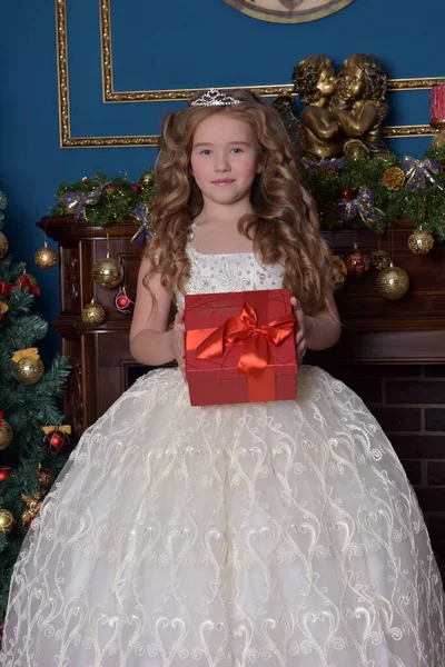 圣诞期间 身穿白衣 头戴皇冠 手里拿着礼物盒的年轻公主 — 图库照片