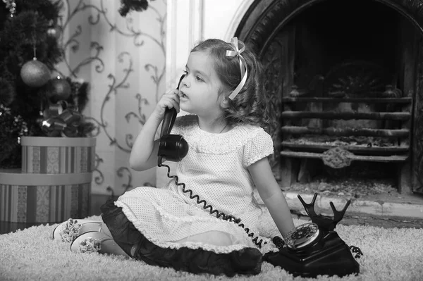 Klein Meisje Zitten Naast Een Vintage Zwarte Telefoon — Stockfoto