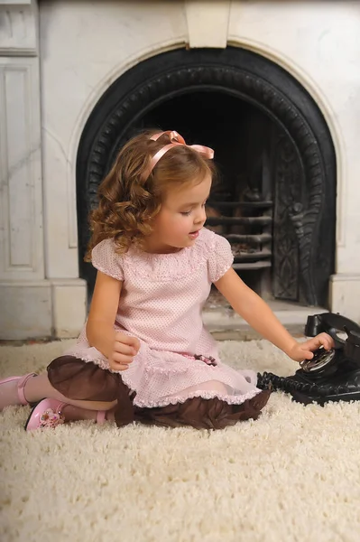 Küçük Kız Antika Siyah Bir Telefonun Yanında Oturuyor — Stok fotoğraf