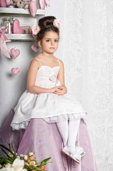 Kleine Brünette Mädchen Einem Weißen Kleid Mit Blumen Haar Sitzt — Stockfoto