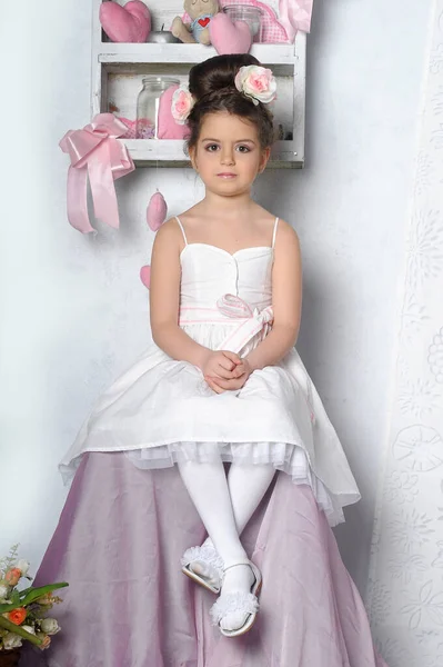 Kleines Brünettes Mädchen Mit Einer Rosa Blume Einer Hohen Frisur — Stockfoto