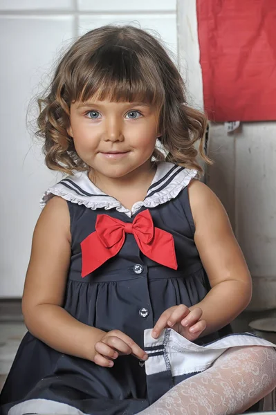 一个黑发小女孩 身穿海军陆战队西服 厨房里的衣服和帽子 — 图库照片