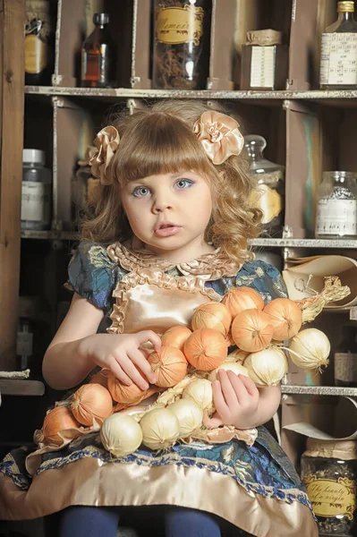 穿着裙子和围裙的小女孩在老式厨房里玩耍 — 图库照片
