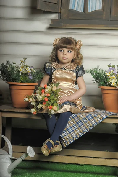 家のベンチに花のついたドレスの少女 — ストック写真
