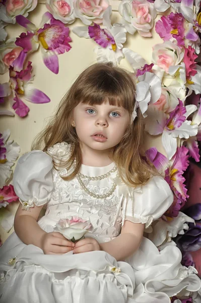Kleines Mädchen Weißen Kleid Auf Einem Stuhl Mit Blumen — Stockfoto
