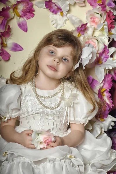 Kleines Mädchen Weißen Kleid Auf Einem Stuhl Mit Blumen — Stockfoto
