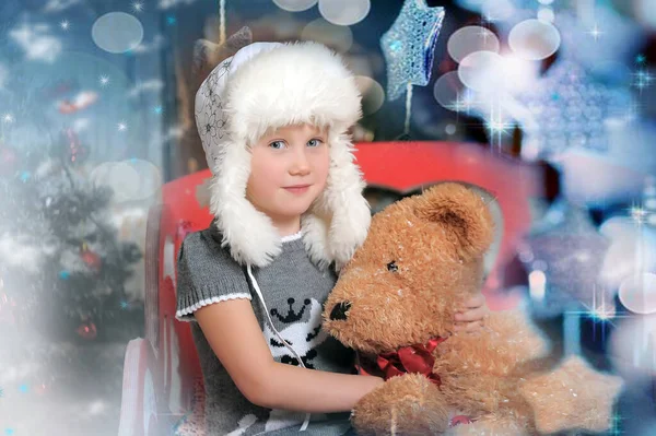 白い毛皮の帽子のかわいい女の子とおもちゃのクマクリスマス写真 — ストック写真