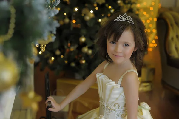 かわいい女の子若い姫ですシックな白いクリスマスドレスで黄金のクリスマスツリー — ストック写真