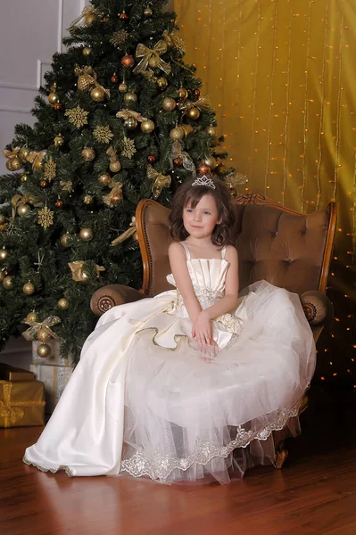 かわいい女の子若い姫ですシックな白いクリスマスドレスで黄金のクリスマスツリー — ストック写真