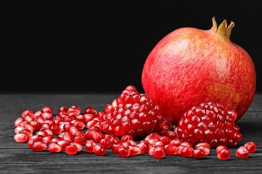 Nar tohumları üzerinde siyah ahşap masa