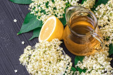Ev yapımı elderflower şurubu siyah ahşap masa, üstten görünüm (seçici odak üzerinde bir cam sürahi)
