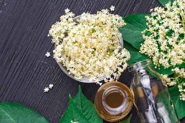 Ev yapımı elderflower şurubu bir şişe siyah ahşap masa, üstten görünüm (seçici odak üzerinde)