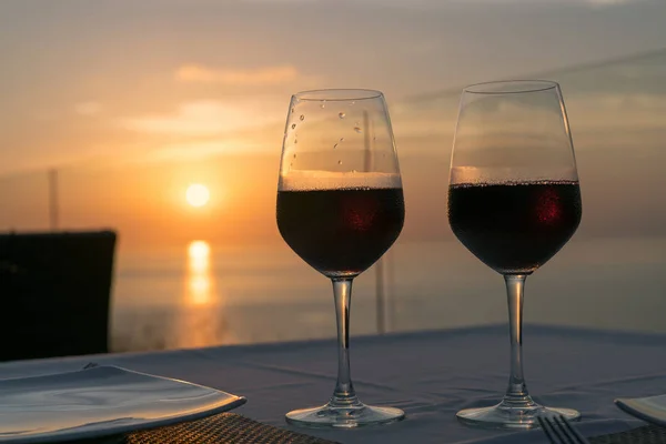 Due bicchieri di vino sullo sfondo del sole al tramonto — Foto Stock