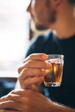 serinletici bir kafe arka planda bir adamın elinde kahverengi çay soğuk cam. dikey fotoğraf.