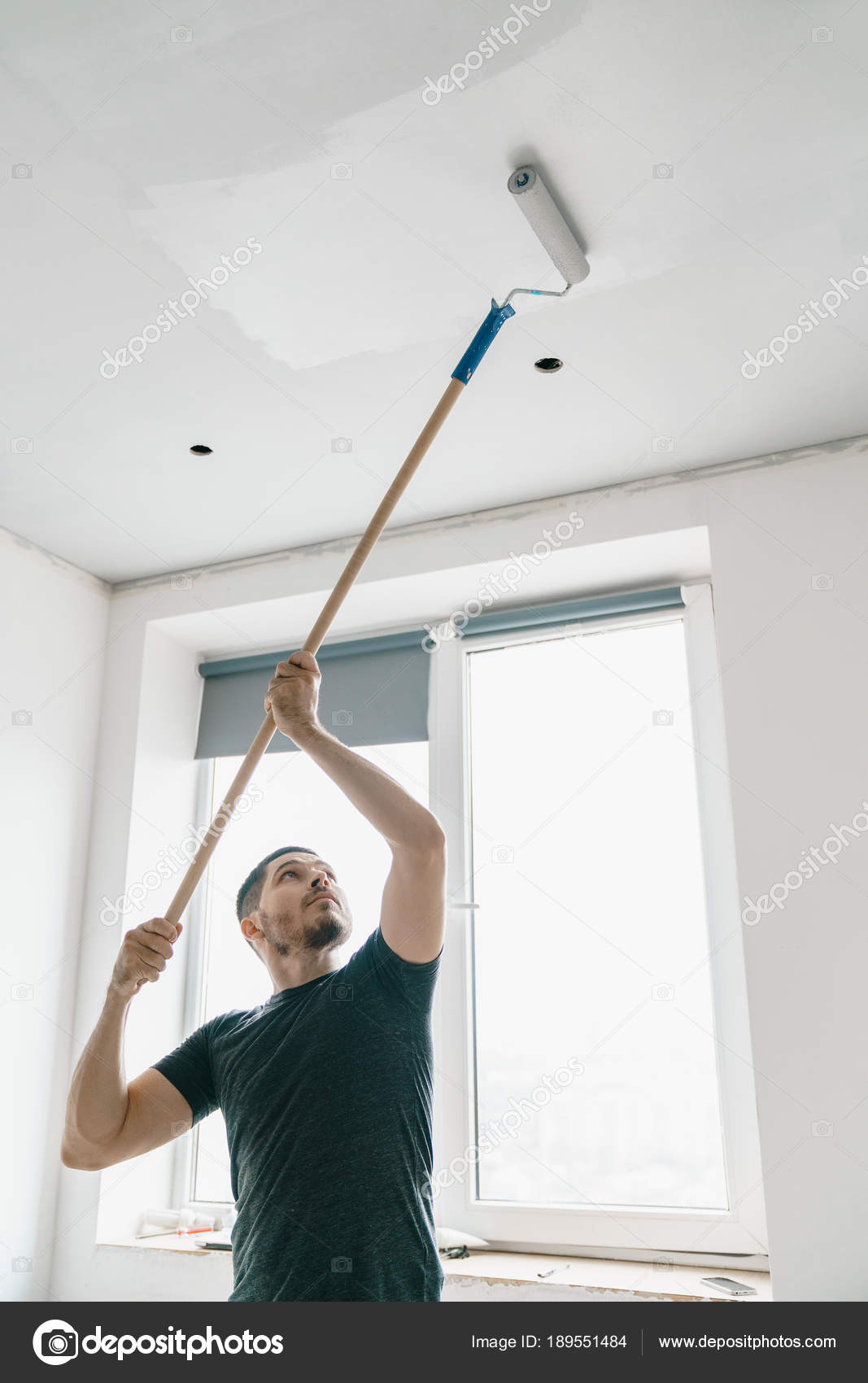 Man Roller His Hand Long Stick Paints Ceiling Gray Window